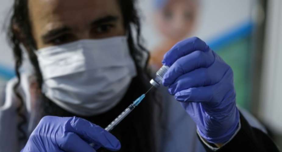 An Israeli health worker prepared a dose of the Pfizer-BioNTech Covid-19 vaccine at Clalit Health Services in Jerusalem earlier this month as part of a vaccination campaign considered one of the largest in the world to date.  By MENAHEM KAHANA AFP