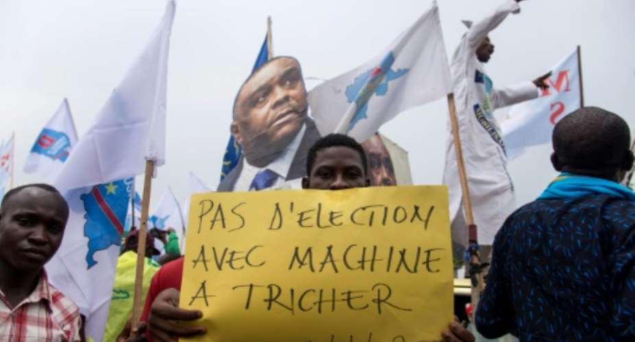 An opposition supporter holds a sign reading No election with a cheating machine -- there have been concerns about the use of electronic voting machines in DRC's poll.  By Junior D. KANNAH AFPFile