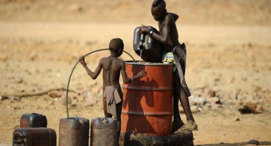 Two Himba boys pour water into a tank in 2010 in the village of Okapare, near Opuwo in northern Namibia.  By Stephane de Sakutin AFPFile