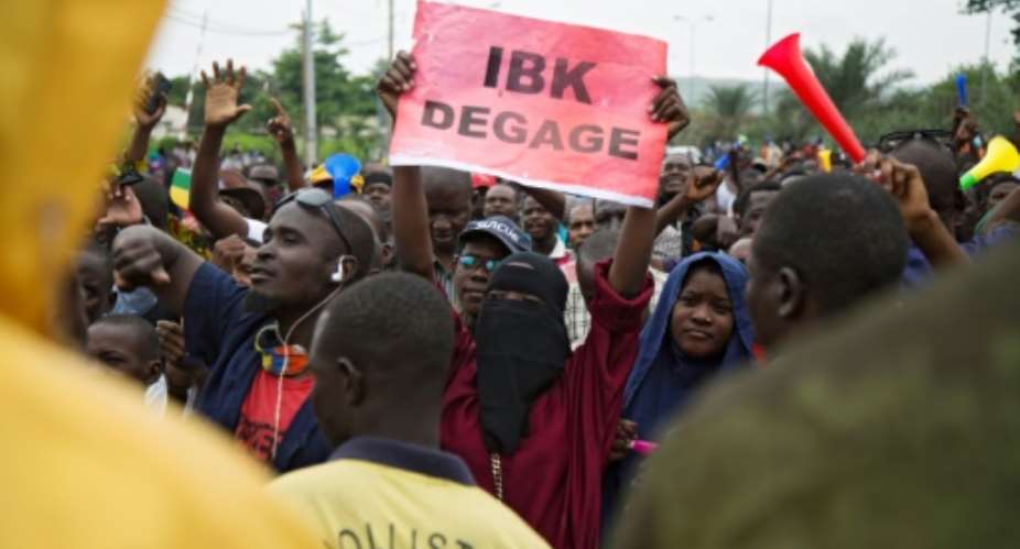 Anger: A demonstrator holds up a sign reading 'IBK out,' referring to President Ibrahim Boubacar Keita by his initials, in a protest in Bamako on August 11.  By ANNIE RISEMBERG AFP