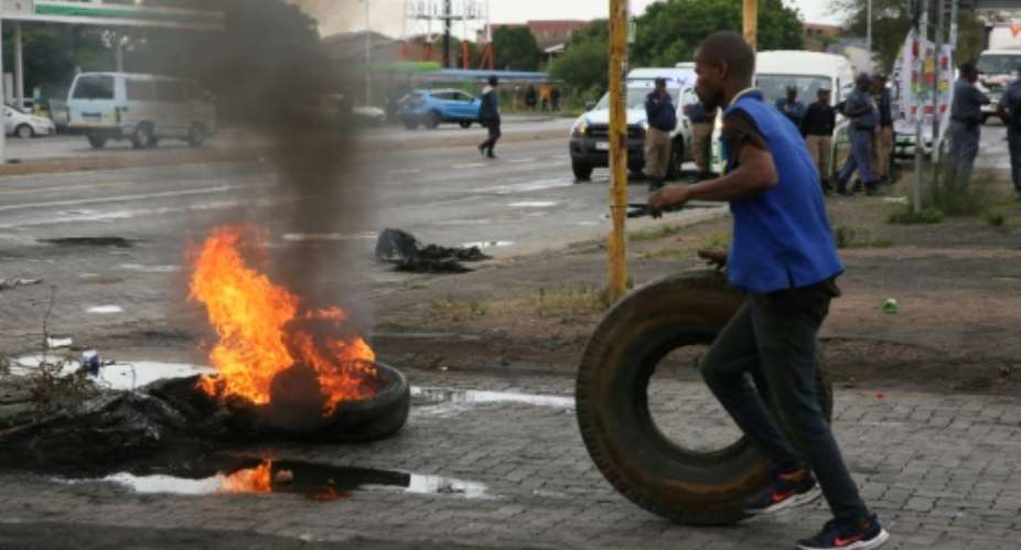 Anger: A resident prepares to throw a tyre on a street barricade in Soshanguve township, north of Pretoria, in a protest on Wednesday about water and power cuts.  By Dinky Mkhize AFP