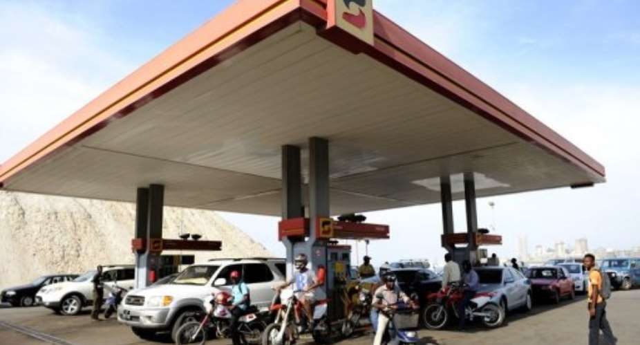 Drivers fill fuel tanks at a gas station in Luanda on December 21, 2009.  By Stephane de Sakutin (AFP/File)