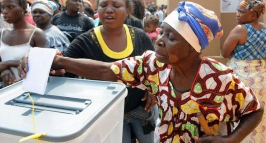 An Angolan R is helped to cast her ballot at a polling station.  By Francisco Leong AFPFile