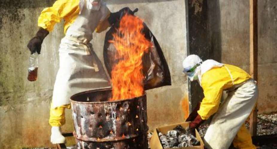 Health workers burn used protective gear at the Medecins Sans Frontieres center in Conakry on September 13, 2014.  By Cellou Binani AFPFile