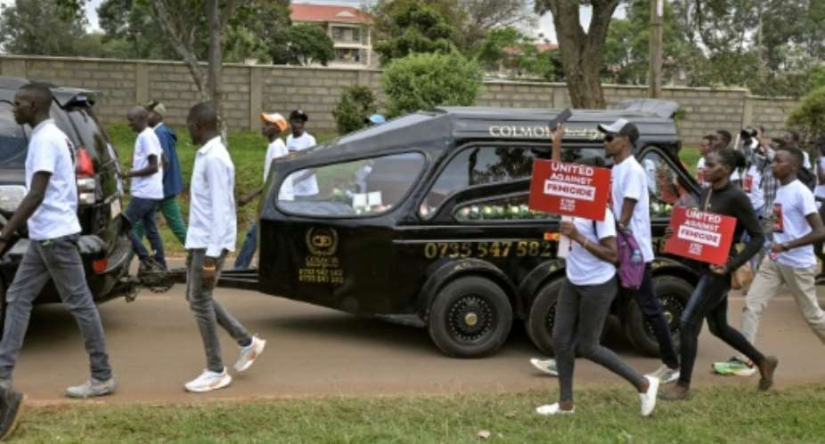 Anti-femicide marchers walk alongside a hearse carrying the body of murdered Olympian Rebecca Cheptegei in western Kenya.  By Brian ONGORO (AFP)