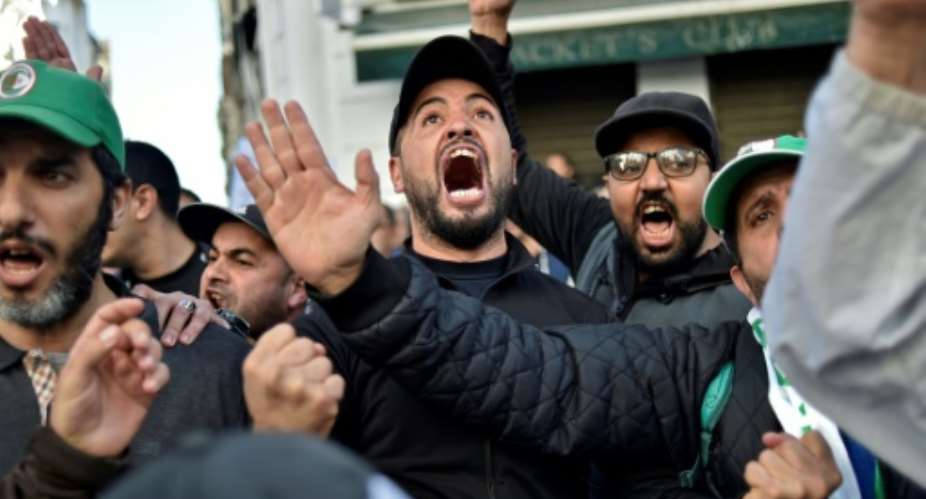 Anti-government protesters in Algiers yell slogans against next month's presidential election on November 29, 2019.  By RYAD KRAMDI AFP