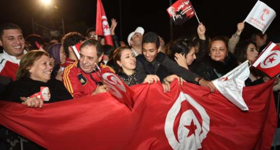 Supporters of Tunisian former prime minister and presidencial candidate Beji Caid Essebsi celebrate the first results of the elections on December 21, 2014 in Tunis.  By Fethi Belaid AFP
