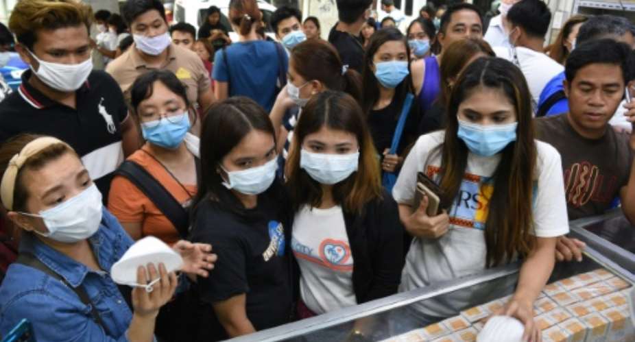 Anxious shoppers try to buy face masks in Manila after the first foreign fatality from the new coronavirus was reported  in the Philippines.  By Ted ALJIBE AFP