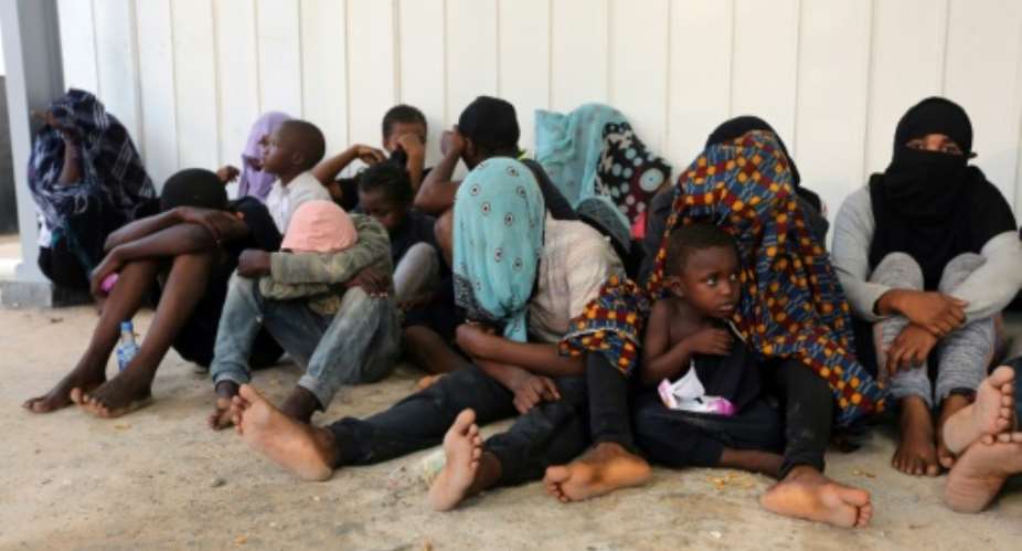 Arab and African migrants gather at a naval base in the Libyan capital Tripoli on September 27, 2017, after they were rescued by the coastguards off the Libyan coast.  By MAHMUD TURKIA AFPFile