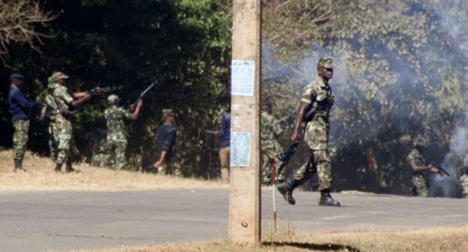 Armed Malawian policemen fired teargas to disperse supporters of The Malawi Congress Party MCP in Lilongwe.  By AMOS GUMULIRA AFP