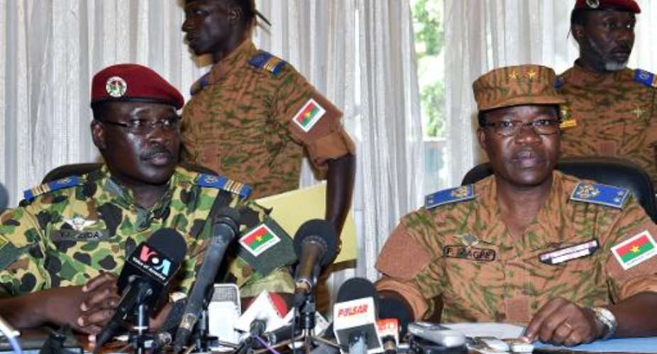 Burkina Faso's Lieutenant-Colonel Yacouba Isaac Zida L listens as Burkina Faso's General Pingrenoma Zagre R reads a statement at the end of a meeting with military commanders on November 1, 2014 in Ouagadougou.  By Issouf Sanogo AFP