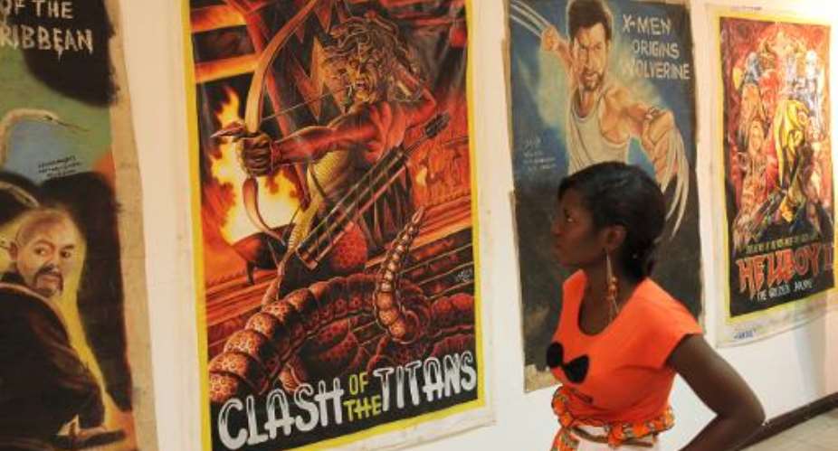 A visitor looks at film posters drawn by local Ghanaian artists during an exhibition in Accra, Ghana, on March 20, 2014.  By Chris Stein AFP
