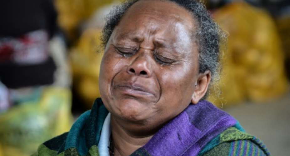 Askale Adacha, 63, weeps as she speaks about fleeing the violence on the outskirts of the Ethiopian capital.  By  AFP