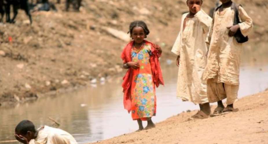 Sudanese children stand next to a water canal in the eastern Kassala State.  By Ashraf Shazly AFPFile