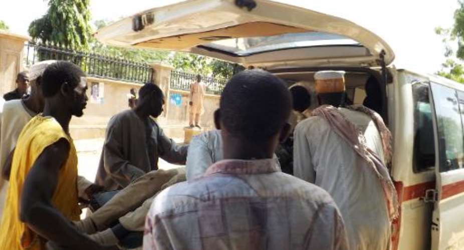 Volunteers load an injured man into an ambulance after a suicide blast in the northeastern Nigerian city of Potiskum on February 1, 2015.  By Aminu Abubakar AFPFile