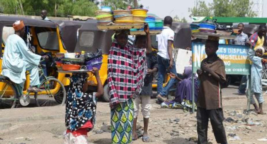 Child food vendors carry trays stacked with food plates at Post Office Area in the northeast Nigerian city of Maiduguri on May 24, 2014.  By Aminu Abubakar AFPFile