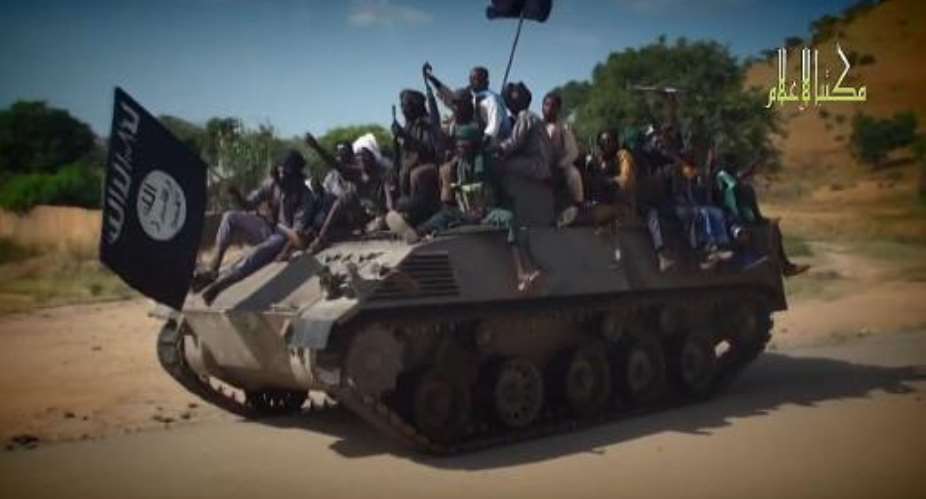 A screengrab taken on November 9, 2014 from a Boko Haram video shows fighters from the group parading on a tank in an unidentified town.  By  Boko HaramAFPFile