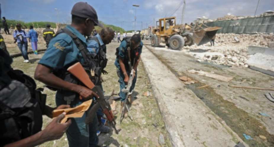 Somali soldiers secure a partially-crumbled perimeter wall following twin car bombings outside UN buildings in Mogadishu on July 26.  By Mohamed Abdiwahab AFPFile