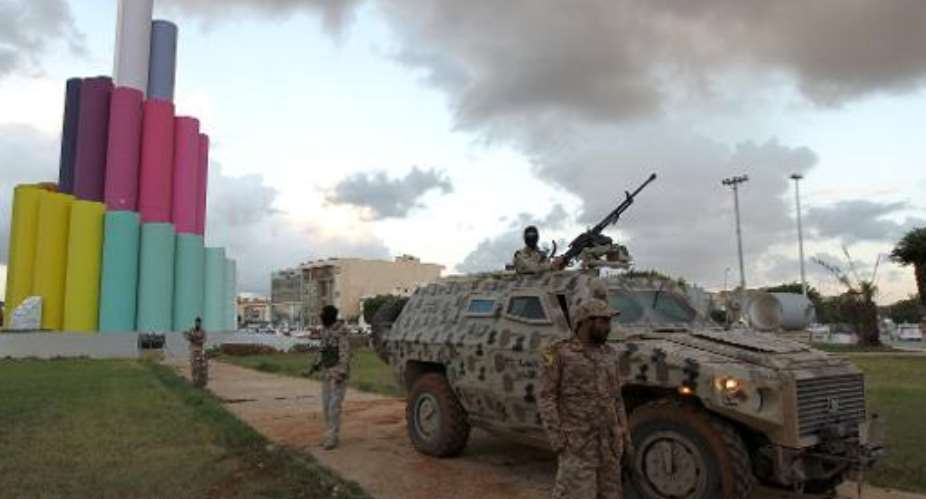 Libyan security members stand by an armored personnel carrier as they patrol the streets of Benghazi on November 14, 2013.  By Abdullah Doma AFP