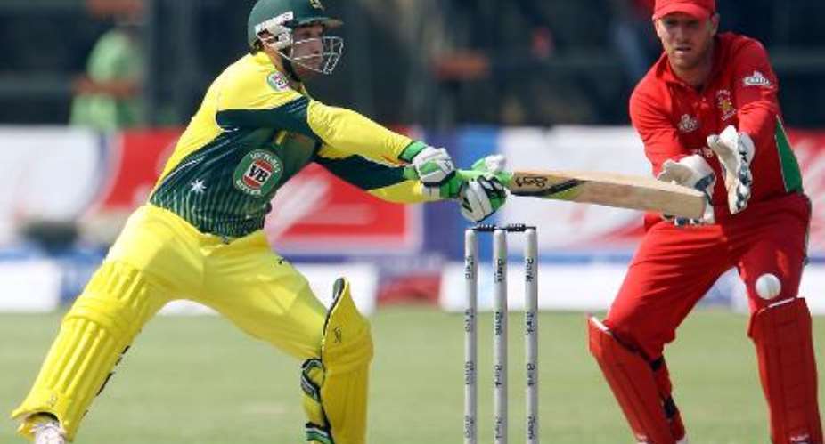 Australia's batsman Phil Hughes L tries to hit the ball next to Zimbabwe's wicketkeeper Brendan Taylor during a one-day international triangular series in Harare on August 31, 2014.  By Jekesai Njikizana AFP