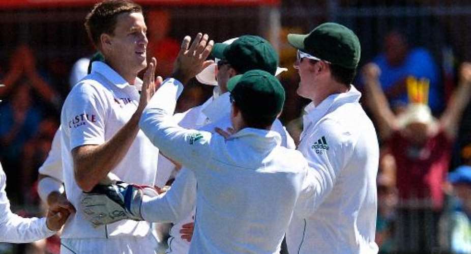 South Africa cricketer Morne Morkel left celebrates with teammates after he cleaned bowled Australia's Nathan Lyon, during their second Test in Port Elizabeth on February 22, 2014.  By Alexander Joe AFP