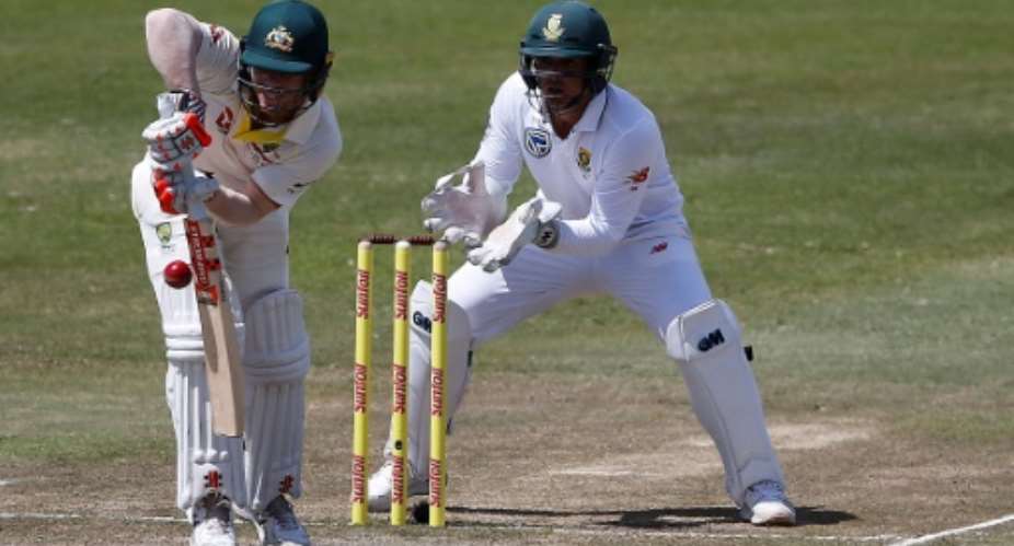 Australian batsman David Warner defends a delivery as South African wicketkeeper Quinton de Kock looks on.  By MARCO LONGARI AFPFile