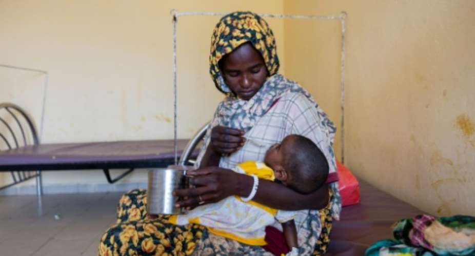 Awa Moussa Karami, a Sudanese refugee, feeds her eight-month-old son, who suffers from malnutrition, at Iriba Hospital in Iriba, in Chad, two of the millions who have fled the civil war in neighbouring Sudan.  By Joris Bolomey (AFP)