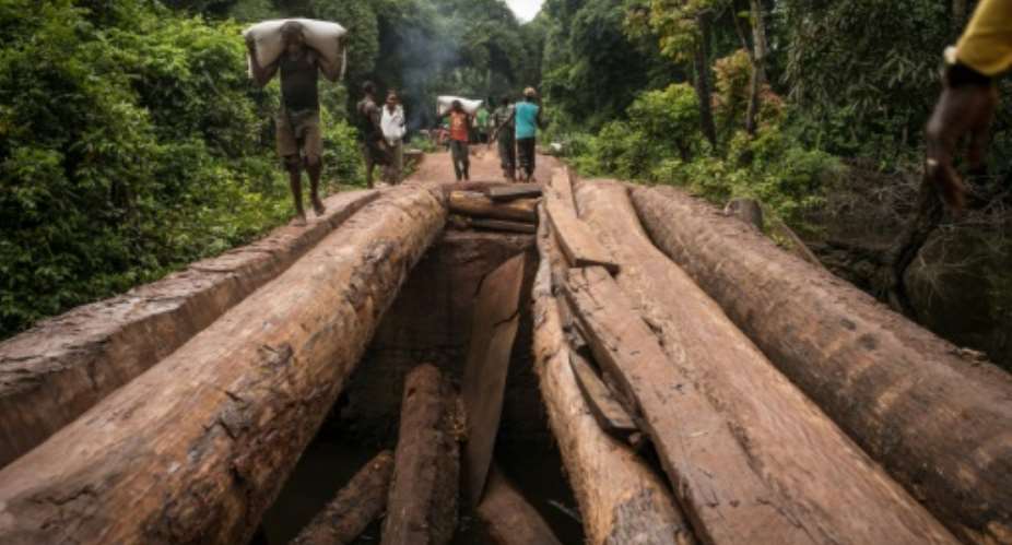 Men carry bags of flour across a damaged bridge on the road between Zongo and Libenge, in the north-western Equateur province of Democratic Republic of Congo.  By Federico Scoppa (AFP)