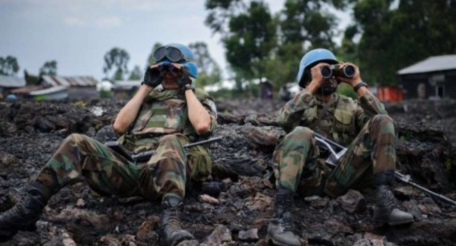 UN peacekeepers look through binoculars at M23 rebel positions on the outskirts of Goma in DR Congo on November 18, 2012.  By Phil Moore AFPFile