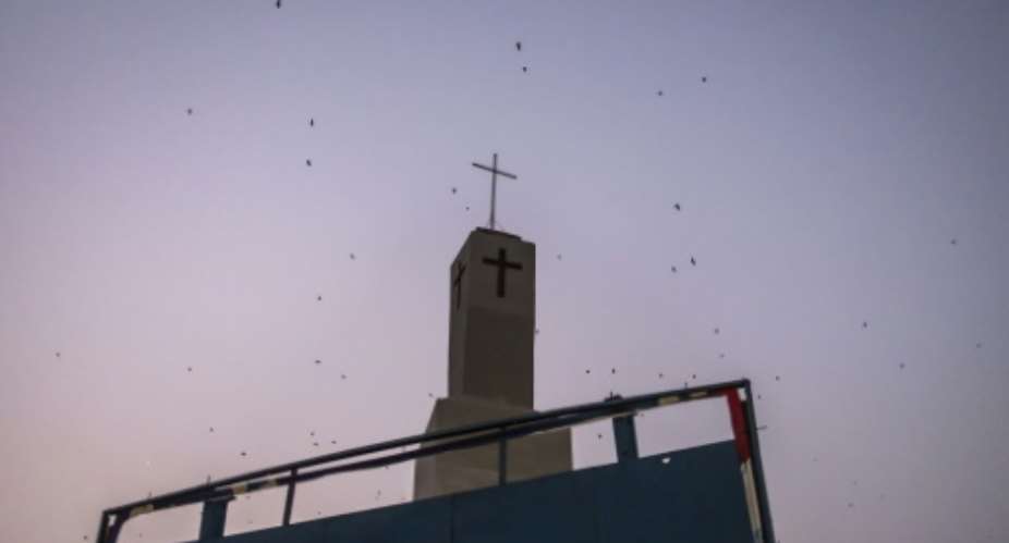 Bats fly over a church tower in Jos, capital of the religiously mixed Plateau state, Nigeria.  By OLYMPIA DE MAISMONT (AFP)