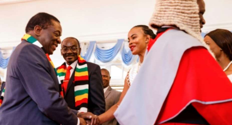Better times: President Emmerson Mnangagwa, left, shakes hands with Marry Mubawaiafter a swearing-in ceremony for new vice presidents.  By Jekesai NJIKIZANA AFPFile