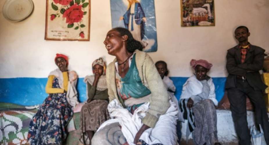 Beyenesh Tekleyohannes cries in her home as a group of relatives look on in the village of Dengolat, north of Mekele, the capital of Tigray, in February 2021.  By EDUARDO SOTERAS AFPFile