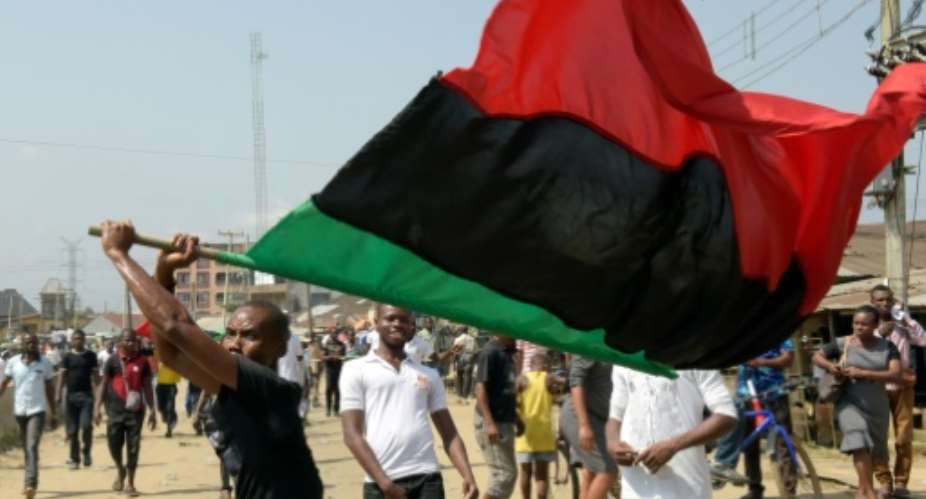 A Biafra supporter waves a flag as people march in Aba, southeastern Nigeria, on November 18, 2015 to call for the release of activist Nnamdi Kanu.  By Pius Utomi Ekpei AFP