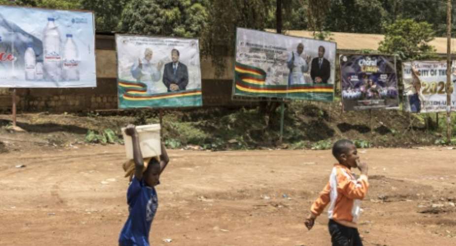Billboards in Bamenda of Pope Leo XIV and Cameroonian President Paul Biya.  By PATRICK MEINHARDT (AFP)