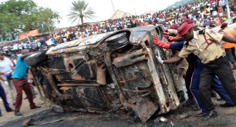 Nigerian security personnel remove the wreckage of a vehicle from the site of a blast at Nyanya bus station in the outskirts of in Abuja on May 2, 2014.  By  AFPFile