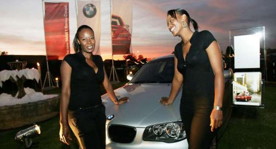 South Africans hang out in Johannesburgs black township of Soweto near a new BMW car on Febuary 28, 2008.  By  ()