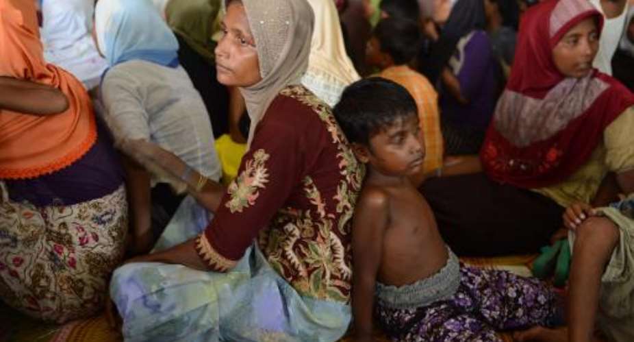 Rohingya women and children from Myanmar sit at a new confinement area in Bayeun, Aceh province on May 21, 2015 after being rescued.  By Romeo Gacad AFP