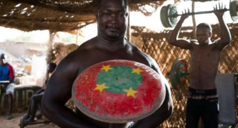 A man lifts a barbell at the MM Club, a weight room in the neighbourhood of Dapoya, Ouagadougou in Burkina Faso on March 10, 2016.  By Nabila El Hadad (AFP/File)