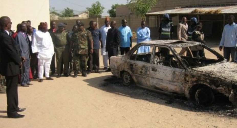 Charred remains of a car in Maiduguri are inspected on December 25, 2010, after Boko Haram had been present in the area.  By Aminu Abubakar AFPFile