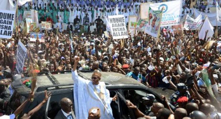 Leading opposition All Progressives Congress presidential candidate Mohammadu Buhari C raises his hand during a campaign rally in Maiduguri, on February 16, 2015.  By Olatunji Omirin AFPFile