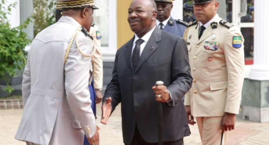 Bongo, centre, shakes hands at a ceremony to honour Gabon's first president.  By STEVE JORDAN AFP