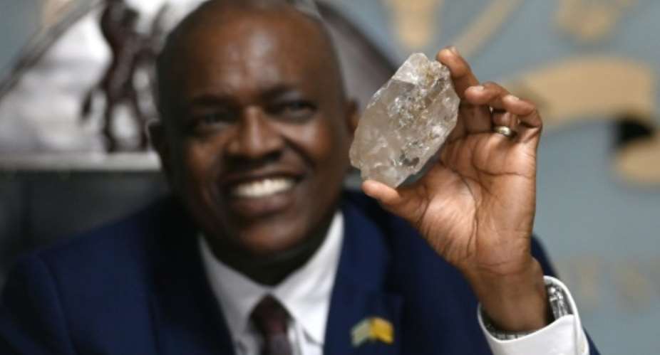 Botswanas President Mokgweetsi Masisi holds a large diamond discovered in Botswana at his office in Gaborone on August 22, 2024.  By Monirul BHUIYAN (AFP)