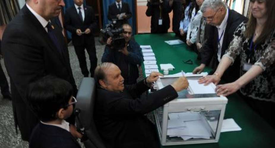 Algeria's ailing President Abdelaziz Bouteflika C, running for re-election, casts his ballot from a wheelchair at a polling station in Algiers on April 17, 2014.  By Farouk Batiche AFP