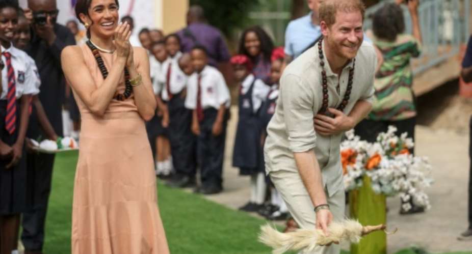 Britain's Prince Harry and his wife Meghan visit a school in Abuja to open an event on mental health for students.  By Kola SULAIMON AFP