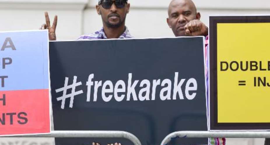 Demonstrators call for the release of Rwanda's intelligence chief General Karenzi Karake outside Westminster Magistrates Court in London on June 25, 2015.  By Justin Tallis AFP