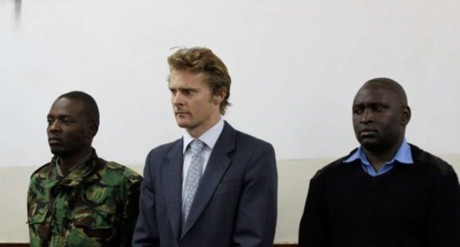 British national Jack Alexander Wolf Marrian C, flanked by police officers, appears in court in Nairobi on August 8, 2016, where he faces charges of trafficking 100 kilos of cocaine from Brazil to the port of Mombasa.  By  AFP