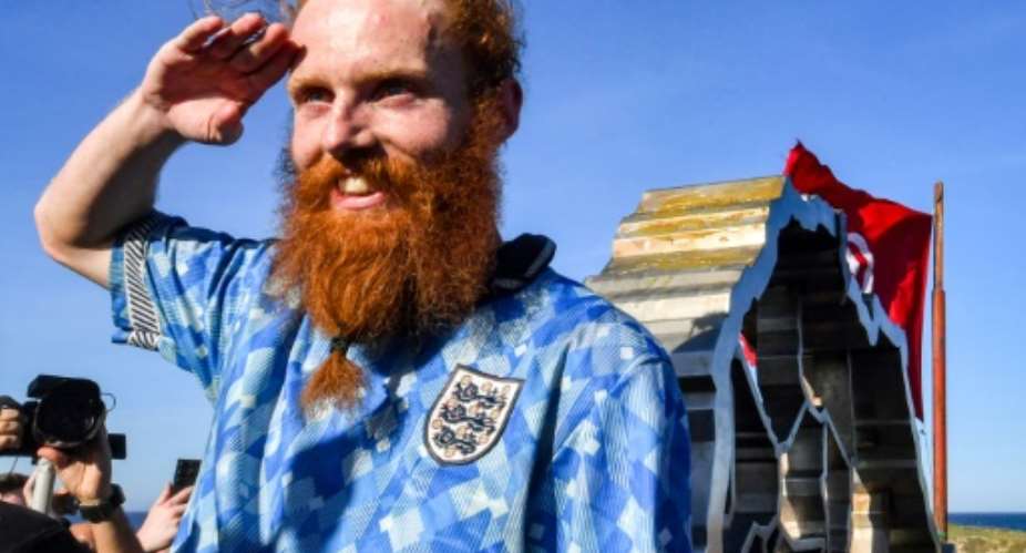 British runner Russ Cook posing at the sculpture marking the northern-most point of Africa after running the full length of the continent.  By FETHI BELAID (AFP)