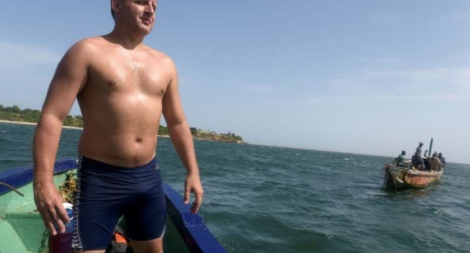 British swimmer Ben Hooper stands on a boat during a training session in Dakar on October 28, 2016.  By SEYLLOU AFPFile
