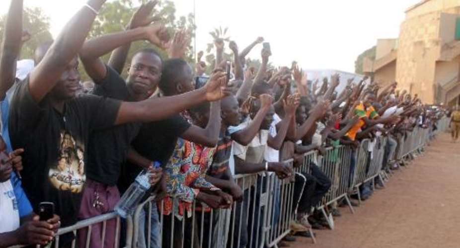 People cheer Burkina Faso's army-appointed leader Lieutenant-Colonel Isaac Zida outside the Maison du Peuple in Ouagadougou on November 16, 2014.  By  AFP