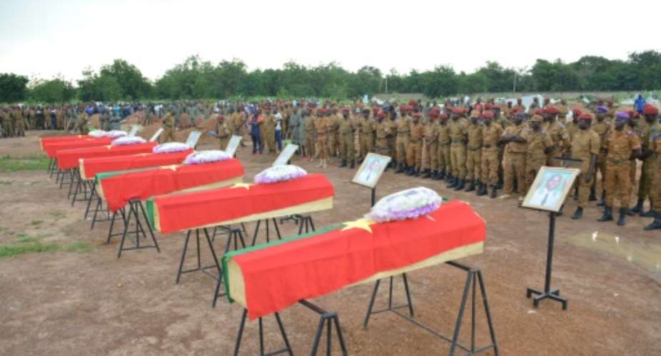 Burkina Faso soldiers in August 2018 pay their respects to soldiers killed when their vehicle struck a roadside bomb in the eastern part of the country.  By STR AFPFile